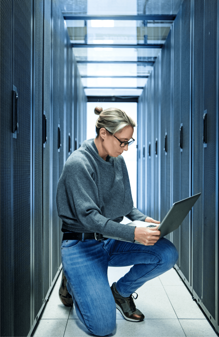 Woman looking at laptop in data centre